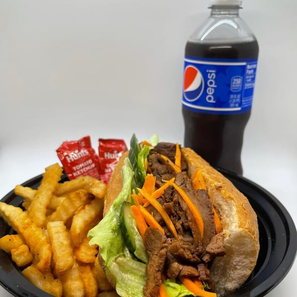 Banh mi sandwich with beef, lettuce, carrots, and cucumber, served with fries and a Pepsi.